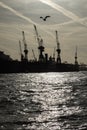 Industrial harbour scenery Ã¢â¬â silhouettes of cranes and a sea g